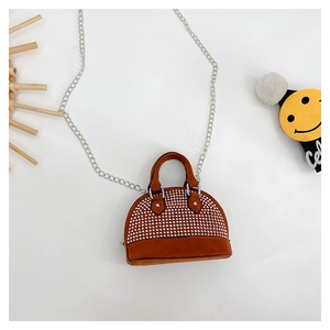 Macro detail of brown suede shell bag with silver rivets and metal chain strap