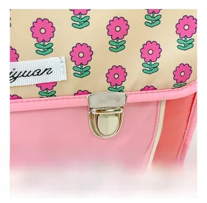 Detail eines rosa geblümten Kinderrucksacks mit silberner Schnalle und Webetikett