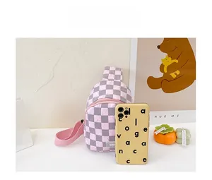 Detailvergleich der rosa karierten Mini-Brusttasche mit einem Smartphone als Größenreferenz