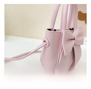 Detailed close-up of pink PU leather mini handbag featuring a large decorative bow