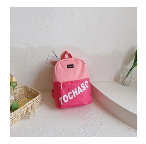 Détail d'un sac à dos d'école en toile rose avec logo TOCHASO et poches zippées solides