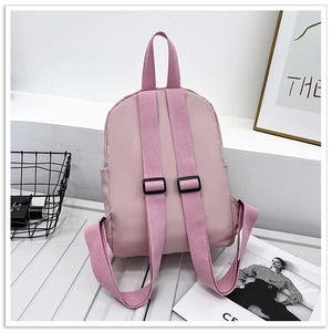 Pink kids backpack featuring adjustable padded straps and side pockets for water bottles