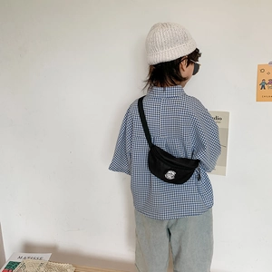 Stylish black kids chest bag with sporty logo worn over a blue plaid shirt