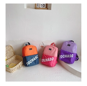 Détail de trois sacs à dos colorés en toile pour enfants avec lettrage de la marque