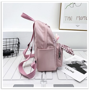Detail of pink children backpack featuring side pocket and cute checkered rabbit ears