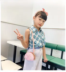 Pink sequin crossbody bag with starfish detail shown on a girl with a plaid shirt