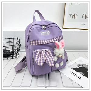Detail of purple canvas backpack with rabbit ears design and cute plush bunny pendant
