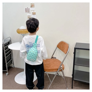 Rückansicht eines Jungen mit einer grünen karierten Brusttasche für Kinder im Alltag.