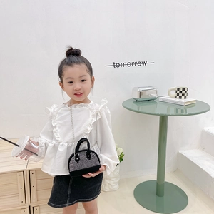 Girl's stylish black rhinestone shell crossbody bag paired with a chic fashion outfit