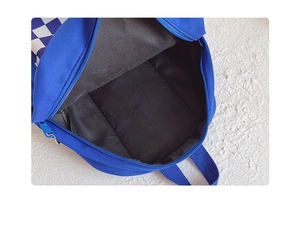 Macro view of blue checkered children backpack showing spacious black interior and zipper