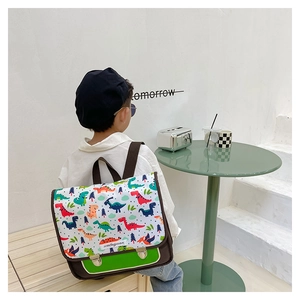 Detailansicht der Kinder-Umhängetasche mit Dinosaurier-Prints und grünem Taschenboden