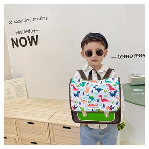 Nahaufnahme eines Kinderrucksacks aus braunem Canvas mit Dino-Prints und grüner Tasche
