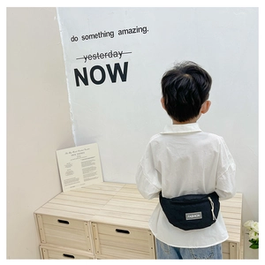 Detail einer schwarzen gesteppten Brusttasche für Kinder mit Reißverschluss und Patch