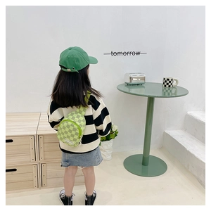 Detail der grünen Kinder-Brusttasche mit Karomuster, FASHION-Logo und passendem Zubehör