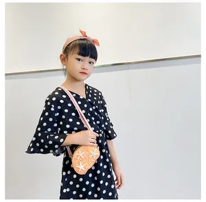 Detail of cute orange sequin shell bag with star decor and polka dot dress