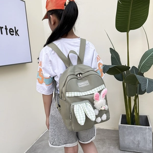 Children's backpack in sage green featuring a cute white bunny doll and plaid details