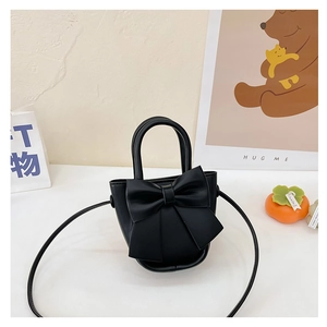 Detailed view of black PU leather mini bow bag with a rigid handle and shoulder strap