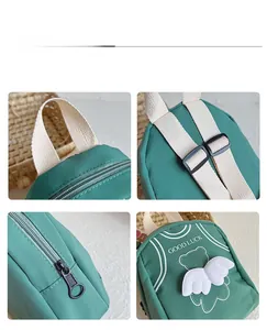 Detail display of kids green canvas backpack with white wings and Good Luck print