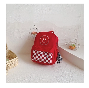 Detail of red kids backpack with smiley face print and checkerboard zip pocket