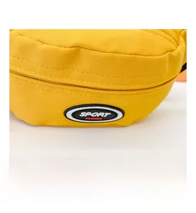 Detail einer gelben Segeltuchtasche mit schwarzem Sport Fashion Aufnäher und feiner Naht