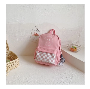 Pink canvas kid backpack detail featuring smiling face and checkered zipper pocket