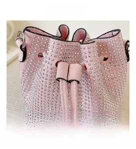Detailed view of pink drawstring bucket bag with silver rhinestones and black trim detail