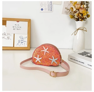 Detail of pink sequin crossbody bag with three white starfish and adjustable strap