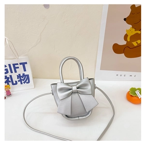 Detail of silver mini bucket bag with metallic bow and elegant top handle strap