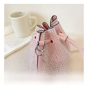Detail showing the shiny rhinestone surface and pink drawstring on this small bucket bag