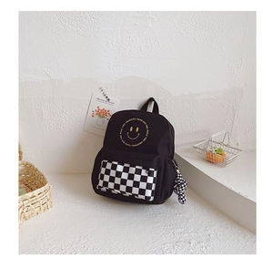 Detail view of children's smile backpack with checkerboard pocket and side charm