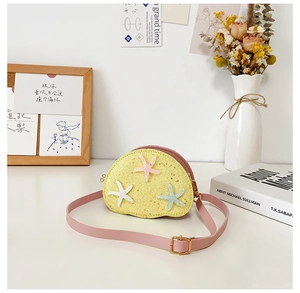 Detail of yellow glitter mini crossbody bag with starfish decor and pink strap