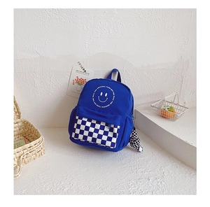 Detail of blue kids backpack with checkerboard front pocket and white smiley face logo
