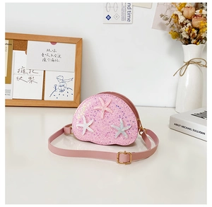 Close-up of pink sequined shell bag with starfish decor and adjustable strap