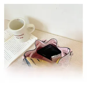 Detail showing the spacious interior of a pink rhinestone bucket bag with silver chain