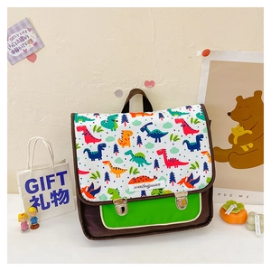 Detail einer braunen Kinder-Umhängetasche mit bunten Dino-Prints und grüner Vordertasche