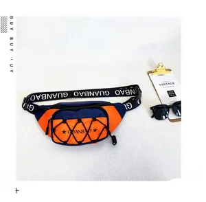 Vue détaillée d'un sac de poitrine en nylon bleu marine et orange avec sangle lettrée