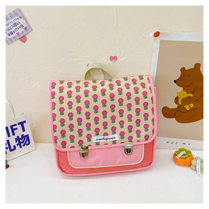 Detail eines rosa Kinderrucksacks mit Blumenmuster und Metallschnallen in Nahaufnahme
