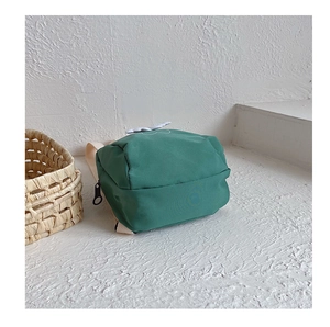 Top view of green canvas mini backpack for kids featuring a decorative cloud patch