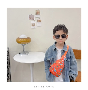 Close-up of child wearing orange canvas chest bag with cute blue dinosaur prints