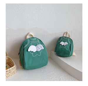 Detail of green kids backpacks with 3D wings and Good Luck print in two sizes