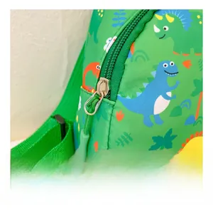 Detail shot of the durable metal zipper and cute cartoon dinosaur print on green canvas