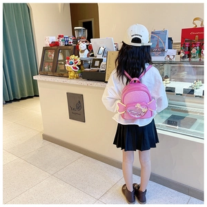 Detail of pink sequin backpack featuring decorative wings and heart pocket for kids