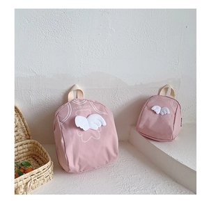 Close-up of pink canvas toddler backpacks with cute 3D wings and bear patterns