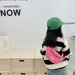 Modische Kinder-Brusttasche im Karomuster und grüne Kappe an einem Jungenmodell