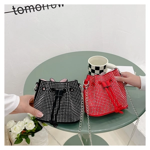 Detail showing red and black drawstring bucket bags with silver rhinestones and chain straps