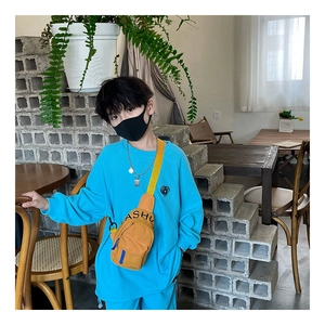 Detail of blue ribbed cotton sweatshirt and yellow canvas fanny pack for kids