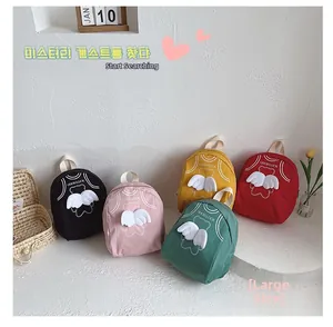 Detail view of five colors of cute canvas kids backpacks with angel wings and prints