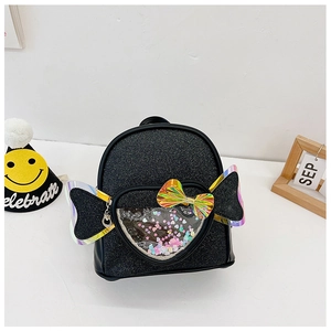 Close-up of a sequined kids backpack with a heart window and iridescent bow detail