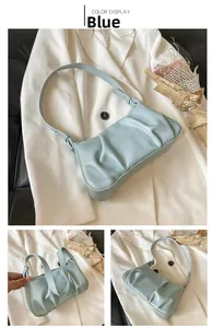 Detail of light blue ruched cloud bag showing pleated texture and slender strap