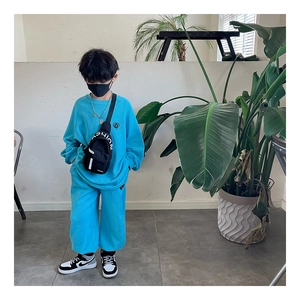 Detail of blue waffle knit sweatshirt set for kids with a stylish black fashion chest bag